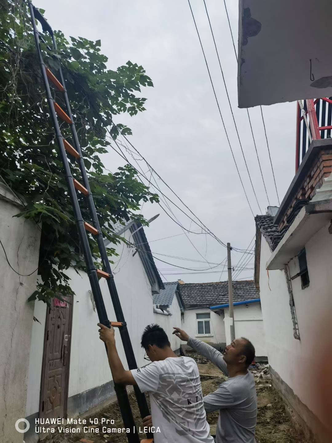 施工人员架设梯子整理凌乱弱电线路