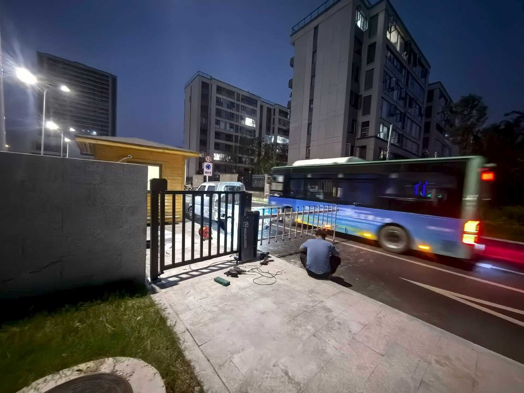利辛公交场站闸机通道监控覆盖工程现场：夜间调试中，蓝绿色新能源公交车正在通过闸机通道